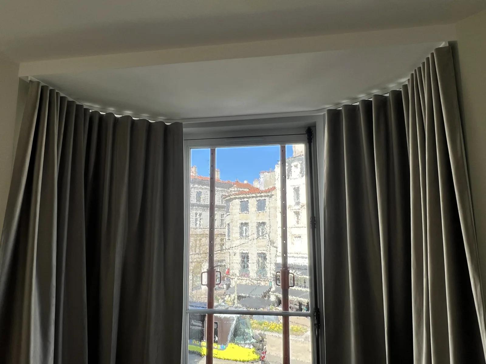 Rideaux occultants taupe en baie d'angle dans un appartement avec vue sur ville