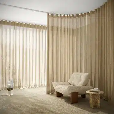 Voilages beige toute hauteur en baie d'angle dans un coin lecture