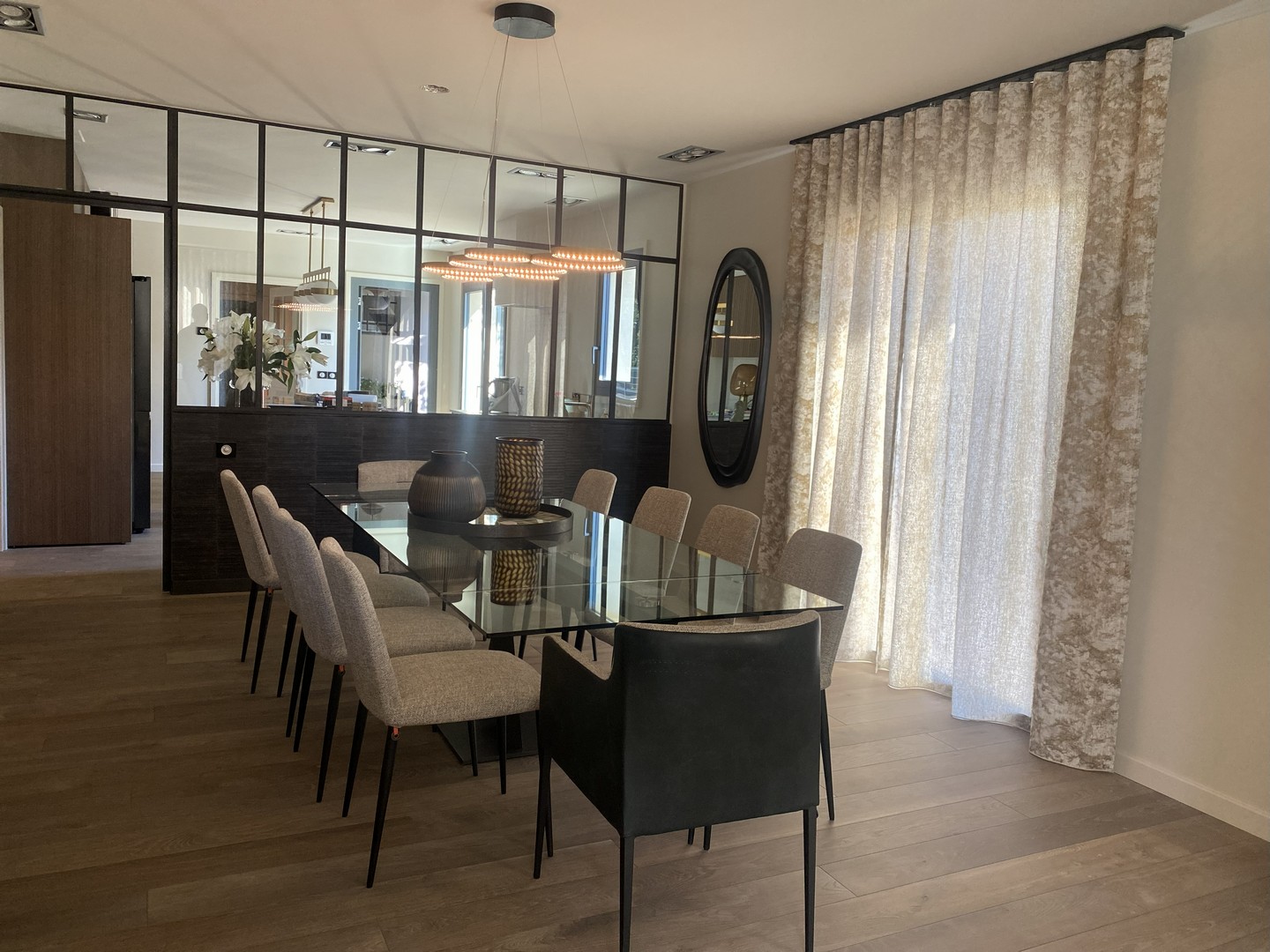 Rideaux tamisants beige clair toute hauteur dans une salle à manger contemporaine avec verrière