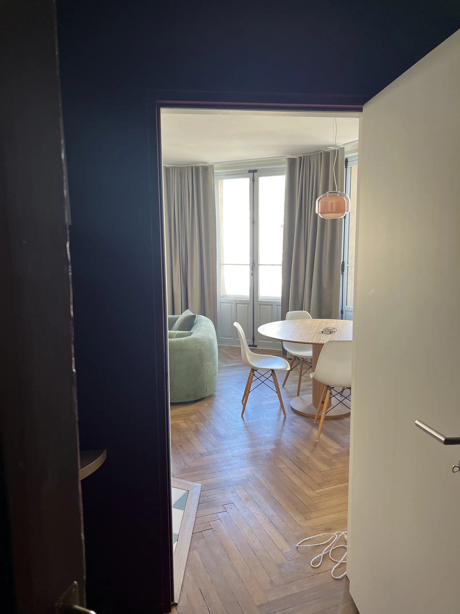 Rideaux taupe élégants dans un appartement haussmannien au parquet point de Hongrie