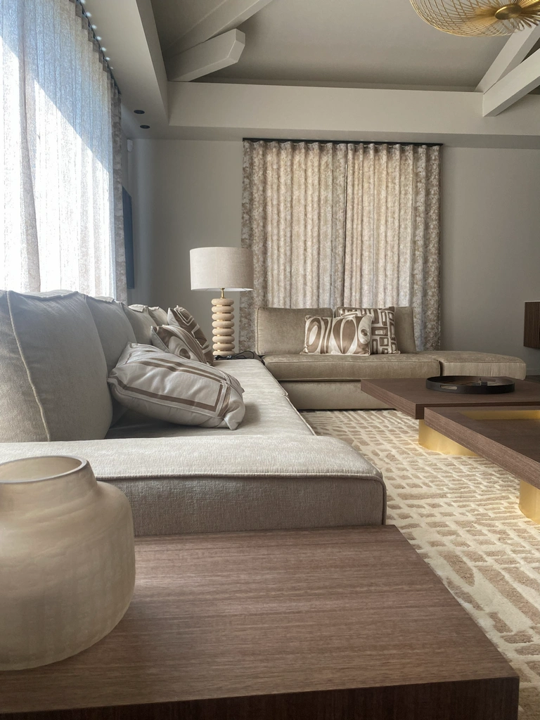 Rideaux à motifs et voilages assortis dans un salon aux tons sable