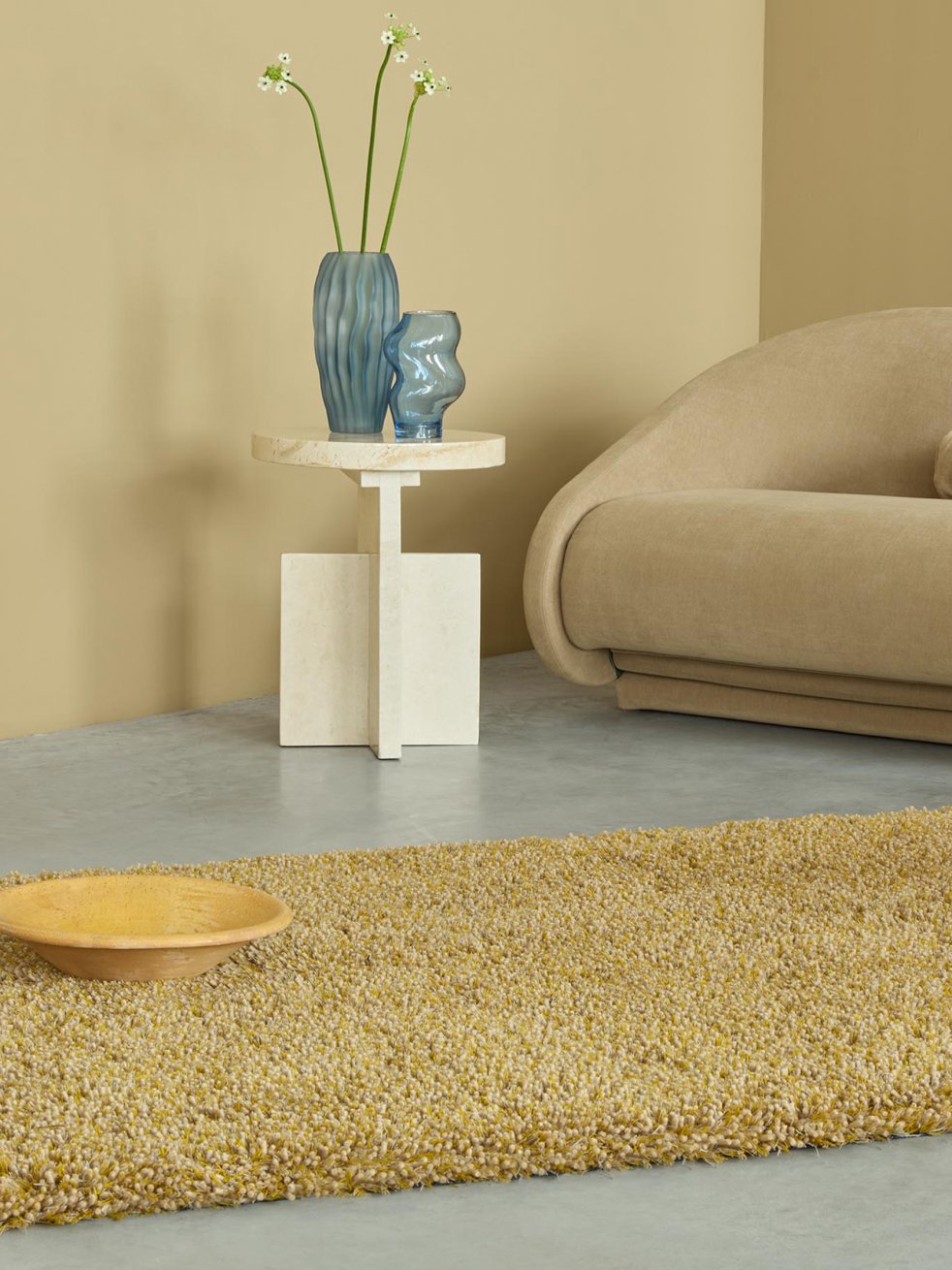 Tapis moutarde texturé dans un salon aux tons sable