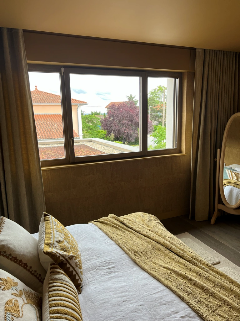 Rideaux et stores enrouleurs dans une chambre avec vue sur jardin