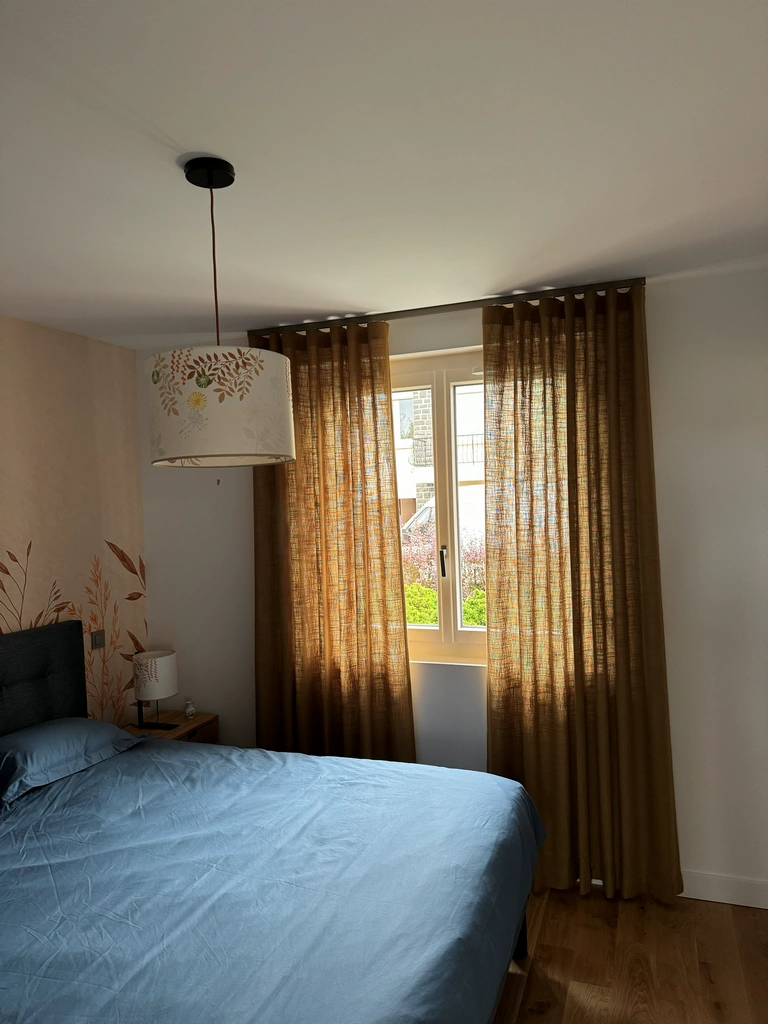 Rideaux en lin brun à galon flamand dans une chambre