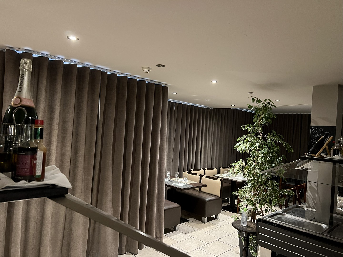 Rideaux occultants taupe posés sur rail plafond dans un restaurant
