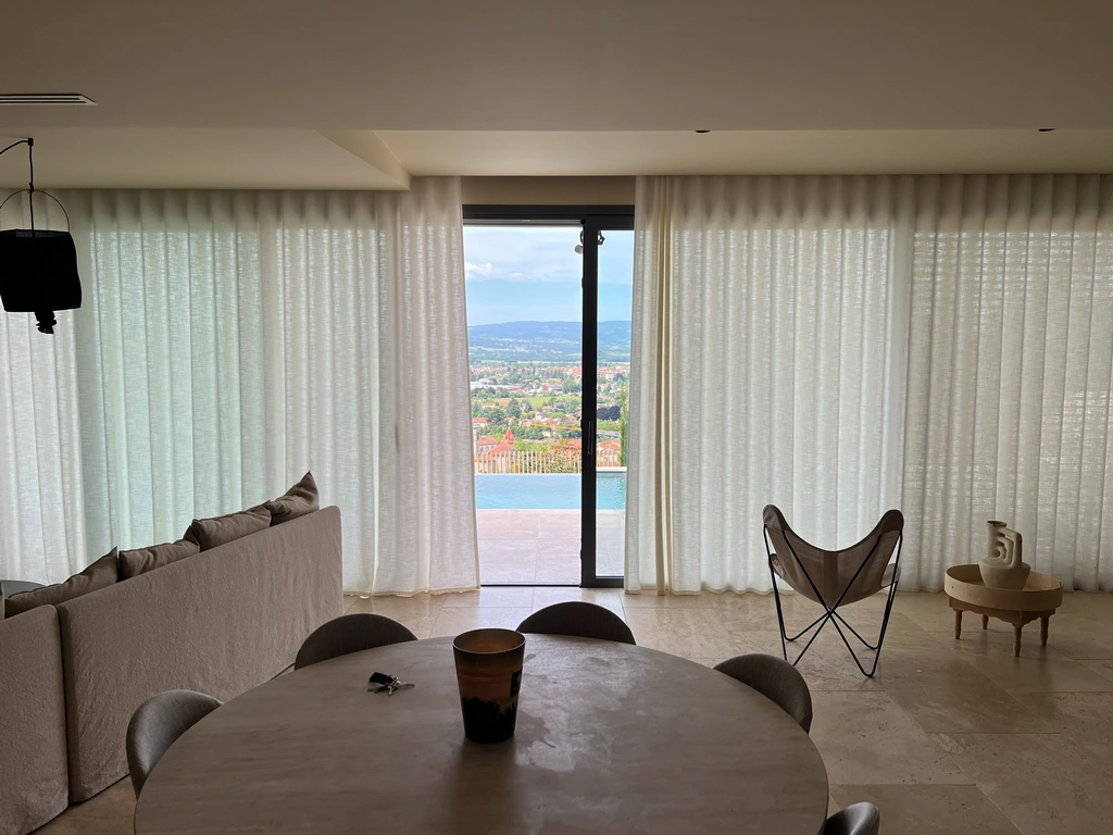 Voilages blancs encadrant une baie avec vue panoramique